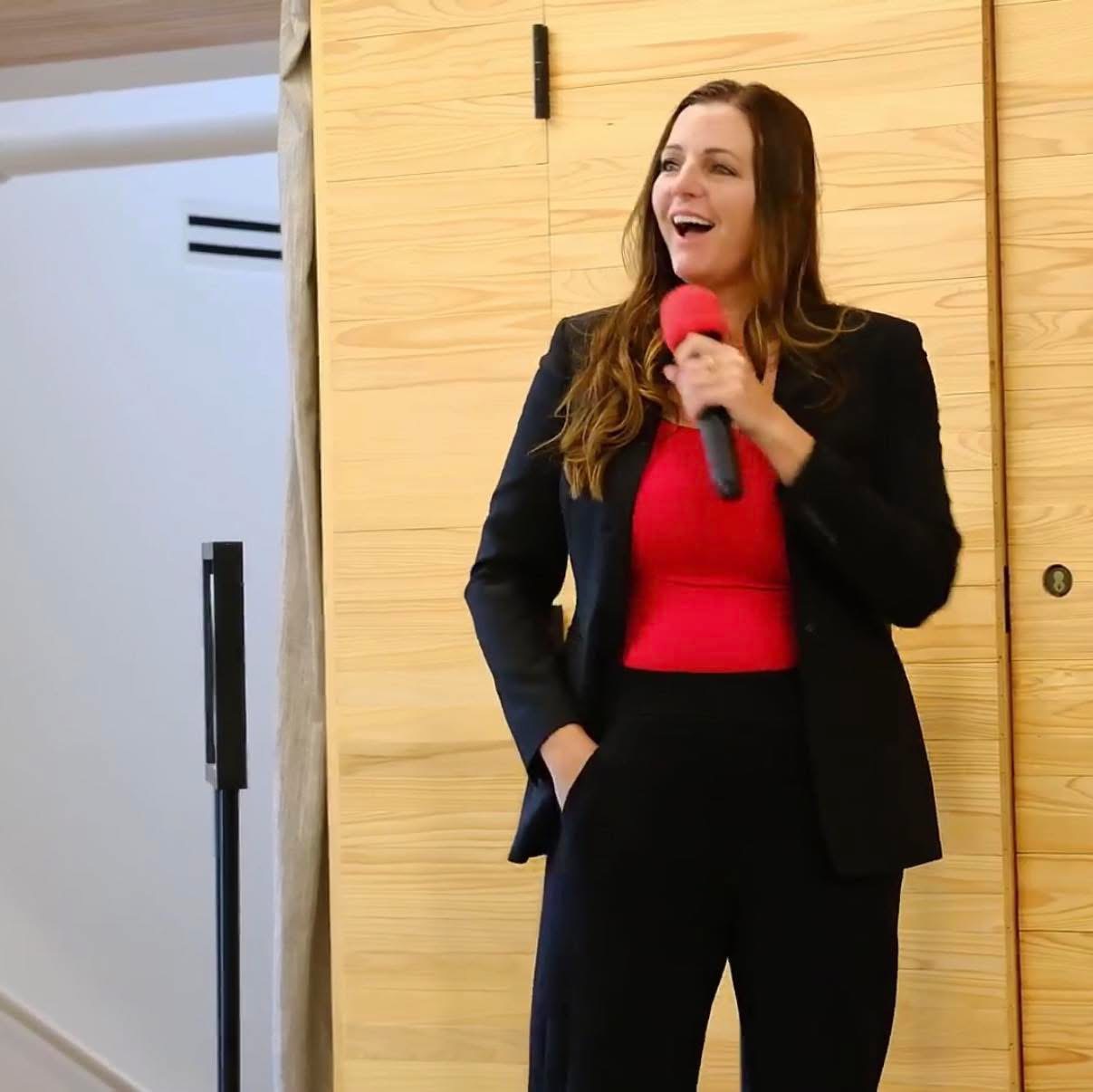 Portrait of the founder of Light Up Consulting, speaking with a microphone